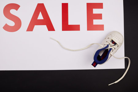 Directly above view of cute baby shoe on shopping banner, Sale of kids shoes concept