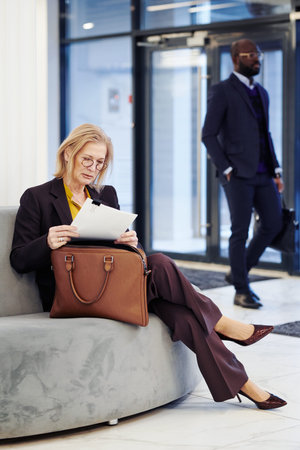 Professional lawyer examining the laws in documents while waiting for the meeting sitting in the...