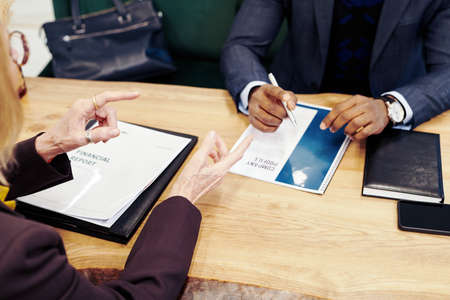 Close-up of businessman signing a contract at the table while having a consultation with lawyer at the table at officeの写真素材