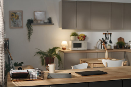 Horizontal image of modern domestic kitchen with gadgets and cup of coffee on tableの写真素材
