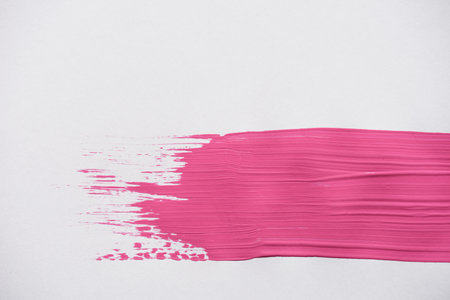 Bright pink stroke smearing on white surfaceの写真素材