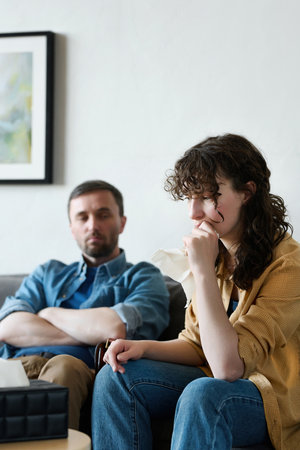 Stressed woman having problems in her family, she sitting at psycho session together with her husbandの写真素材