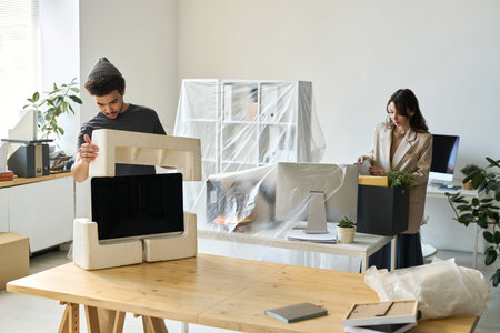 Young business people packing things during the move in other officeの写真素材
