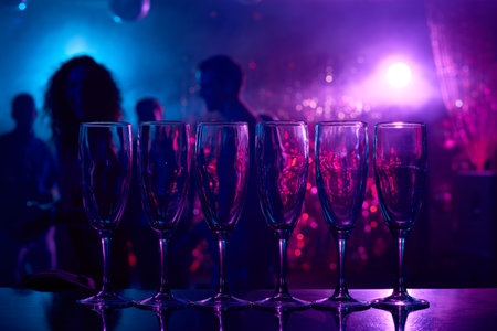Champagne flutes in row on bar counter in nightclubの写真素材