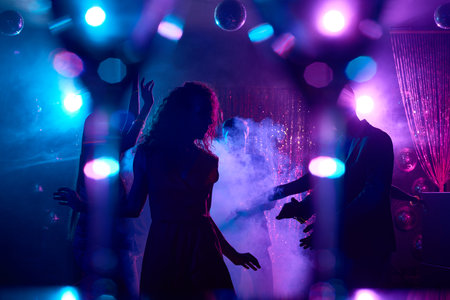 Young people dancing in smoke and enjoying nightlifeの写真素材