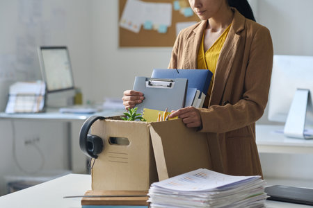 Young businesswoman packing her things in box during move in new officeの写真素材