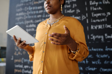 African American teacher using digital tablet to explain new material to students at lessonの写真素材
