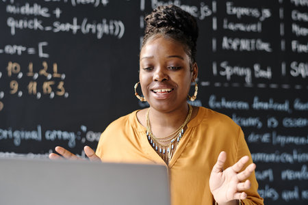 African American student sitting in front of laptop and having video call with studentの写真素材