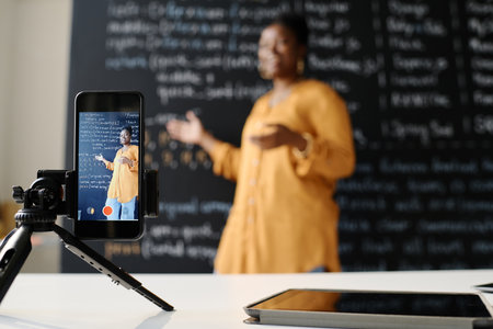 African American teacher using smartphone to teach students IT profession onlineの写真素材