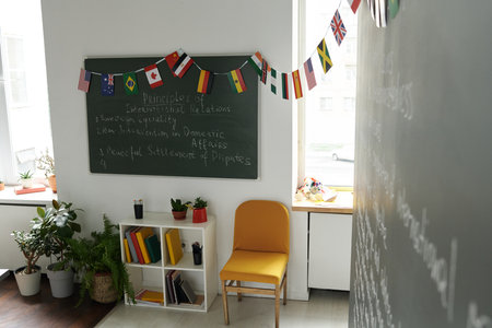 Modern empty classroom with blackboard and flags at schoolの写真素材