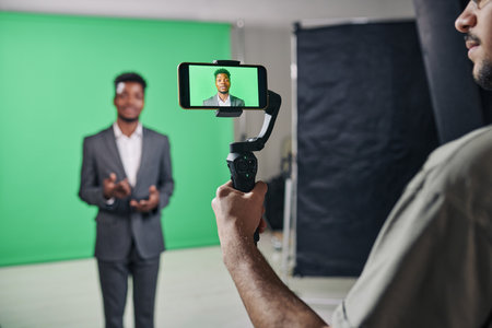 Cameraman shooting th presenter on smartphone while he speaking on cameraの写真素材