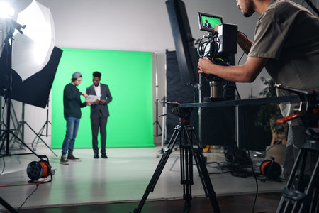 Cameraman shooting TV program on professional camera in studioの写真素材