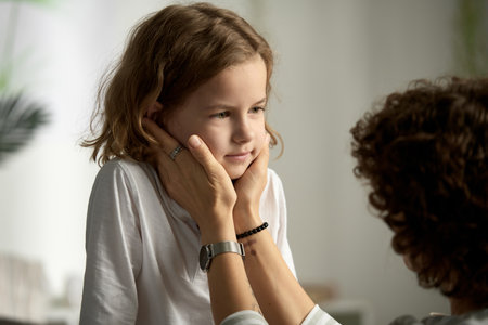 Little boy listening and talking to his mom while she showing her care and supporting himの写真素材