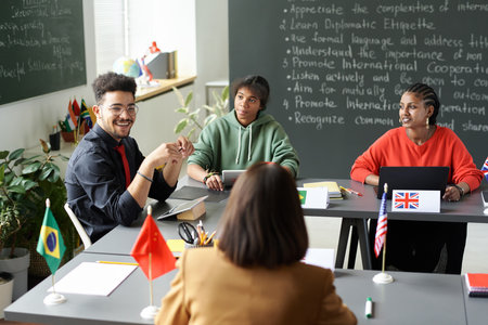 Rear view of teacher talking to multiethnic students during seminar in the classroomの写真素材