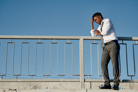 Young depressed man standing on the bridge and thinking about suicideの写真素材