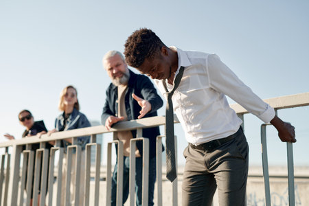 Depressed guy getting ready for jump while other people trying to save himの写真素材