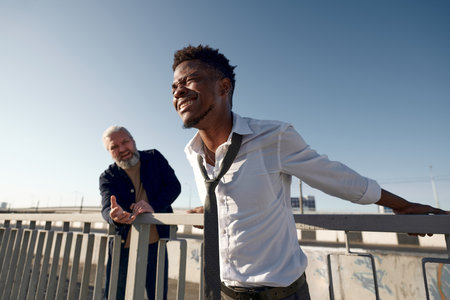 African American depressed man jumping from bridge while passer trying to save himの写真素材