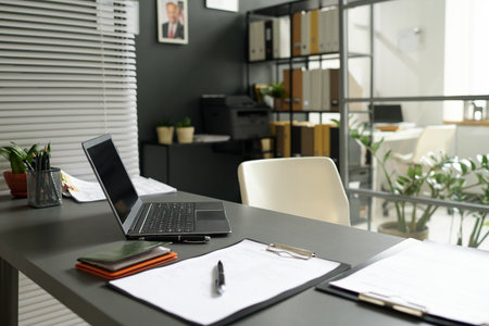 Modern workplace of consultant with laptop and documents in officeの写真素材