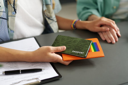 Close-up of lesbian couple giving passports to get married while filing documents and having meeting with consultantの写真素材