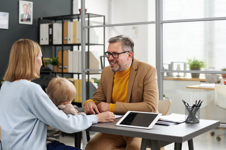 Young mother visiting social worker with her little son in officeの写真素材