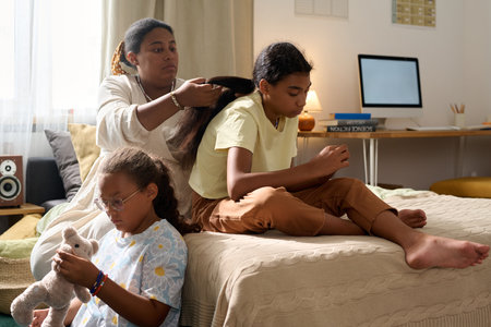 African American mother spending time with her daughters in the roomの写真素材