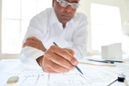 Close up of unrecognizable male architect drawing plans with focus on hand holding pencil, copy spaceの写真素材