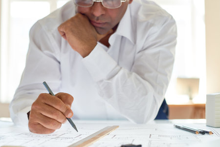 Unrecognizable architect designing plans with focus on hand holding pencil, copy spaceの写真素材