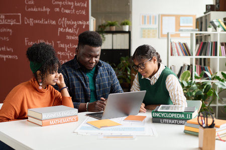 Group of Black students using laptop in their study during teamwork at table in classの写真素材