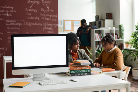 Background image of computer with blank white screen on table in college classroom copy space