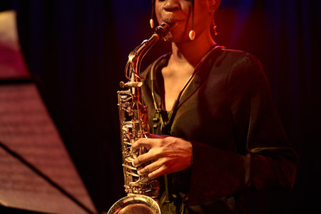 Close up of young Black woman playing saxophone performing jazz music on stage copy spaceの写真素材