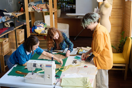 High angle view at diverse group of girls sewing clothes together in inclusive schoolの写真素材