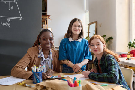 Portrait of Black adult woman with two teenage girls looking at camera in atelier workshop, copy spaceの写真素材