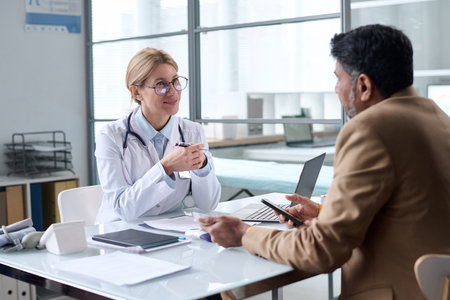 Portrait of smiling female doctor talking to patient in clinic and enjoying work copy spaceの写真素材