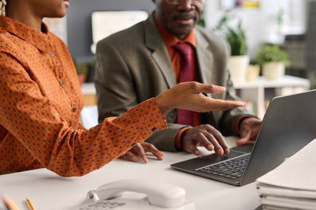 Close up of female hand pointing at computer screen during business meeting with senior colleague in office copy spaceの写真素材