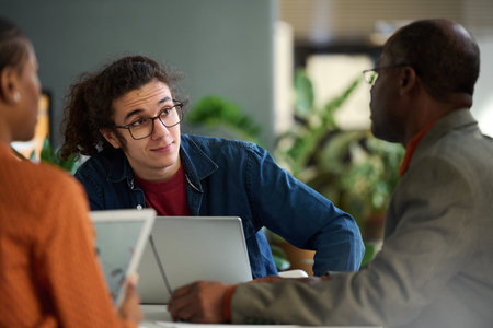 Portrait of gen Z young man collaborating with senior colleague in business meeting copy spaceの写真素材