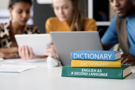 Close up background image of stacks of books on table with students studying in background, copy spaceの写真素材