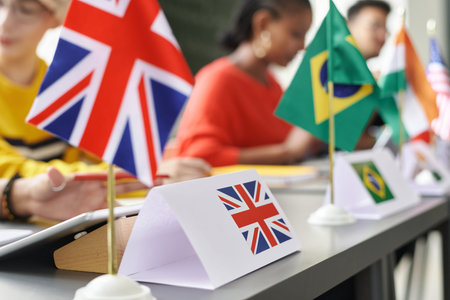 Close up of British flag on table during international conference in school classroom with students...