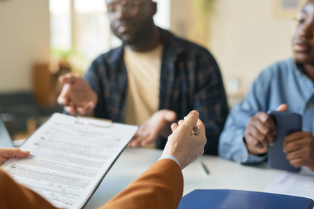 Close up of unrecognizable female specialist holding clipboard while consulting couple on law or...