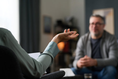 Two people engaging in a counseling session with therapist attentively listening and gesturing with hand, creating an environment of understanding and supportの写真素材