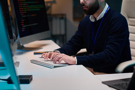 Cropped shot of bearded software developer writing code and typing on computer keyboard in office copy spaceの写真素材