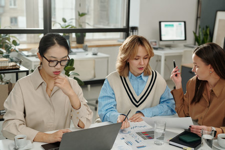 Group of young women planning business strategy and discussing plans during work meeting in officeの写真素材