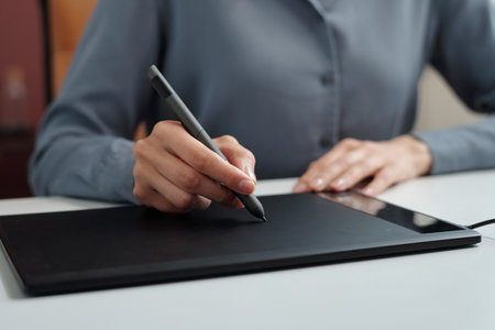 Close up of unrecognizable businesswoman using drawing tablet at workplace in office copy spaceの写真素材