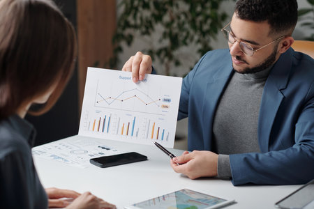 Portrait of businessman pointing at document with data statistics and presenting strategy during business meeting copy spaceの写真素材