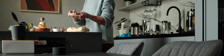 Person kneading dough on kitchen counter surrounded by culinary tools and ingredients creating fresh...