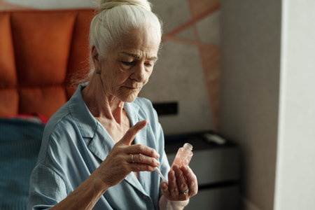 Elderly woman with white hair bun while sitting indoors wearing a light blue shirt