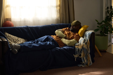 Relaxing on couch with sunlight streaming through window, showing a cozy living space decorated with...