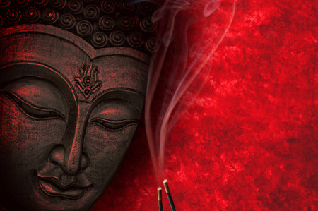 Buddha image with red background and incenseの写真素材