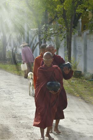 Inle, Myanmar, september-09-2015 Buddhist monks leaving the convent to collect donations and foodのeditorial素材