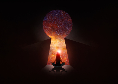Woman in front of open door with universe behindの写真素材