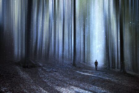 Man walking through a surreal forestの写真素材